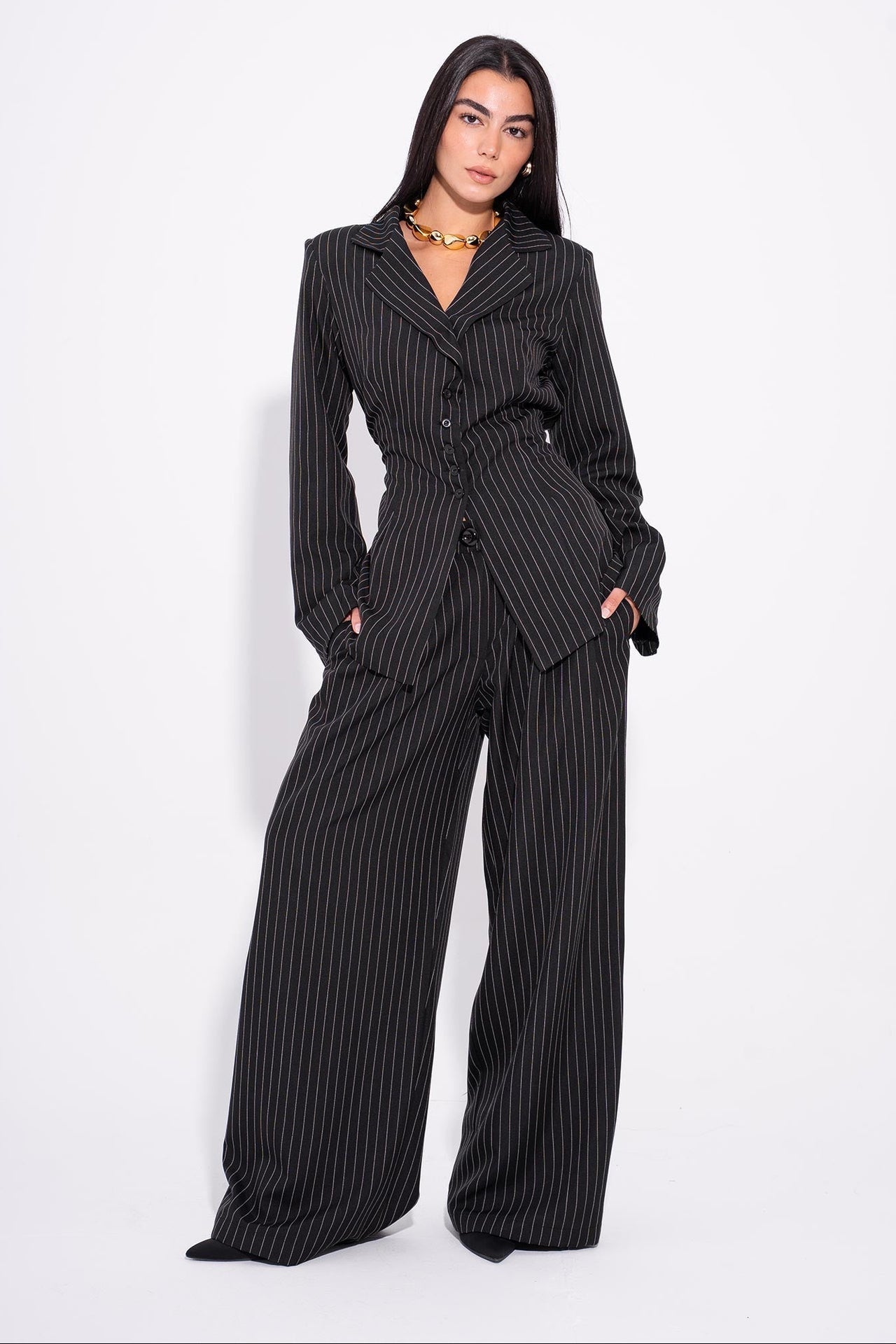 Woman wearing a black pinstripe suit on a white background